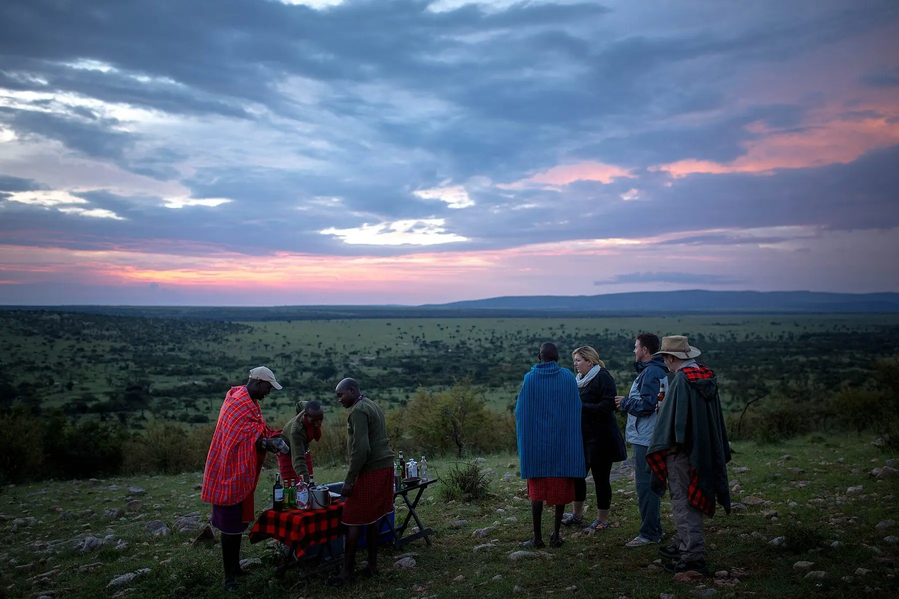 Guests and Maasai guides gathered at dusk in the Ol Kinyei Conservancy, Kenya